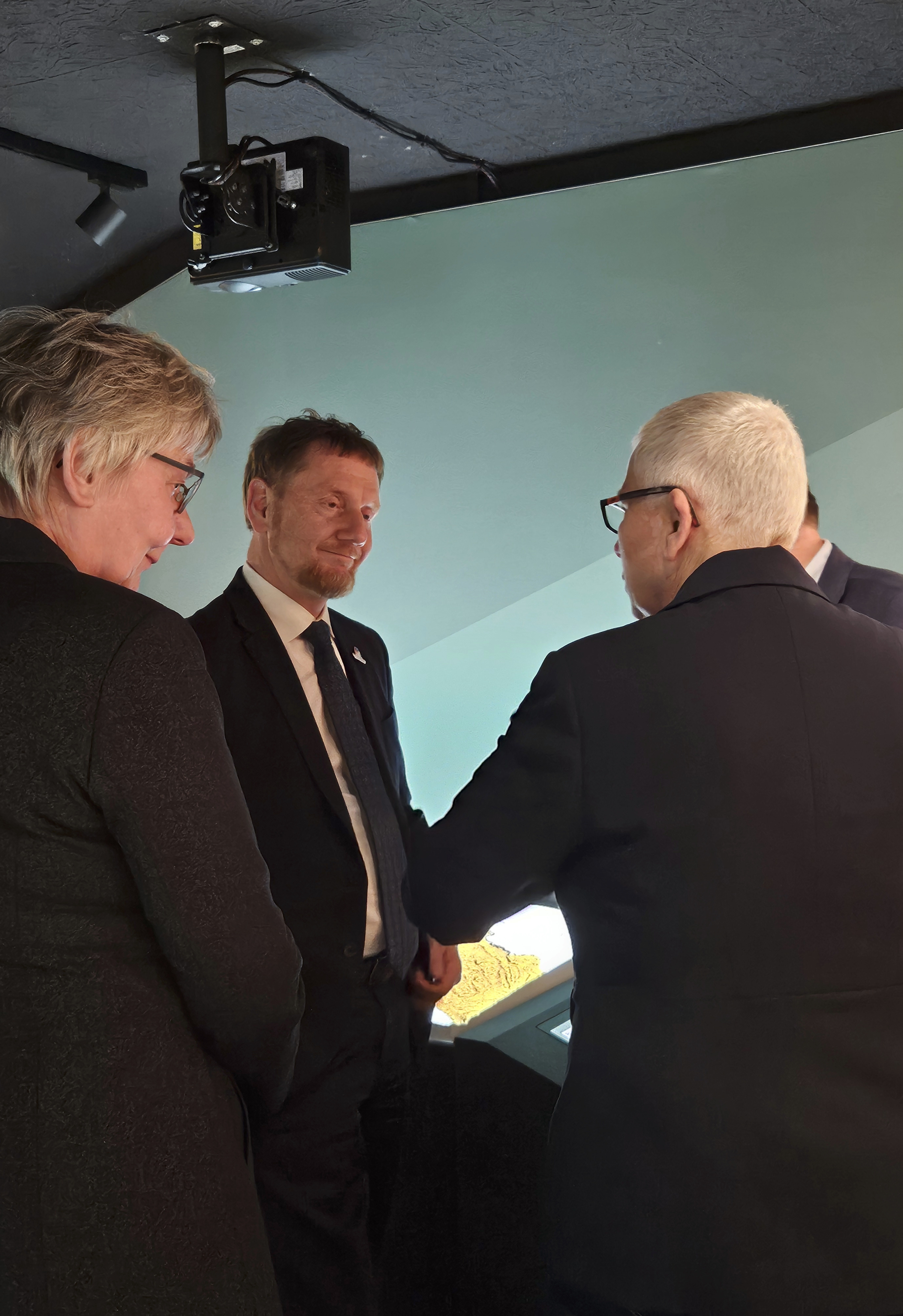 Ministerpräsident Michael Kretschmer (m.) im Gespräch mit Dr. Regina Smolnik (l.) und Dr. Christiane Hemker (r.) / Předseda Michael Kretschmer (uprostřed) při rozhovoru s Dr. Reginou Smolnik (vlevo) a Dr. Christiane Hemker (vpravo) | Zinn und Sein