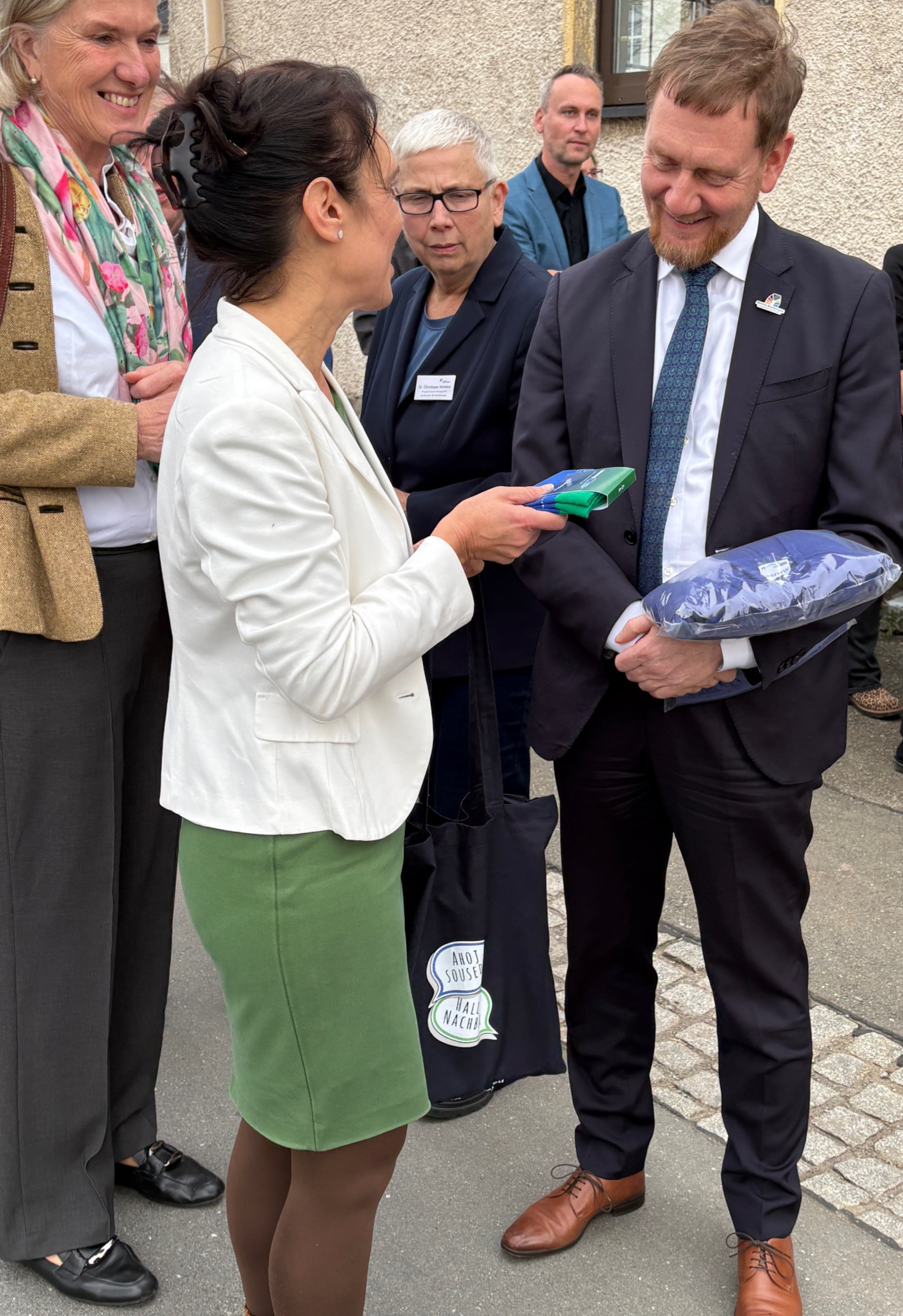 Nadja Franke (l.) übergibt Interreg-Präsent an Ministerpräsidenten Michael Kretschmer (r.) / Nadja Franke (vlevo) předává dárek ministerskému předsedovi Michaelu Kretschmerovi (vpravo). | Zinn und Sein