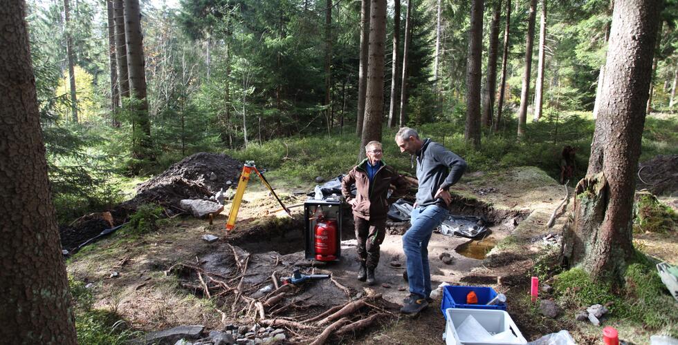 Erzgebirgischer Heimatverein Eibenstock e.V.: | Copyright: In der Sauschwemme: T. Helm (Erzgebirgischer Heimatverein Eibenstock e.V.) und H. Hönig (ArchaeoTin, LfA) diskutieren Grabungsbefunde der Kampagne 2024 (© F. Schröder, LfA).
